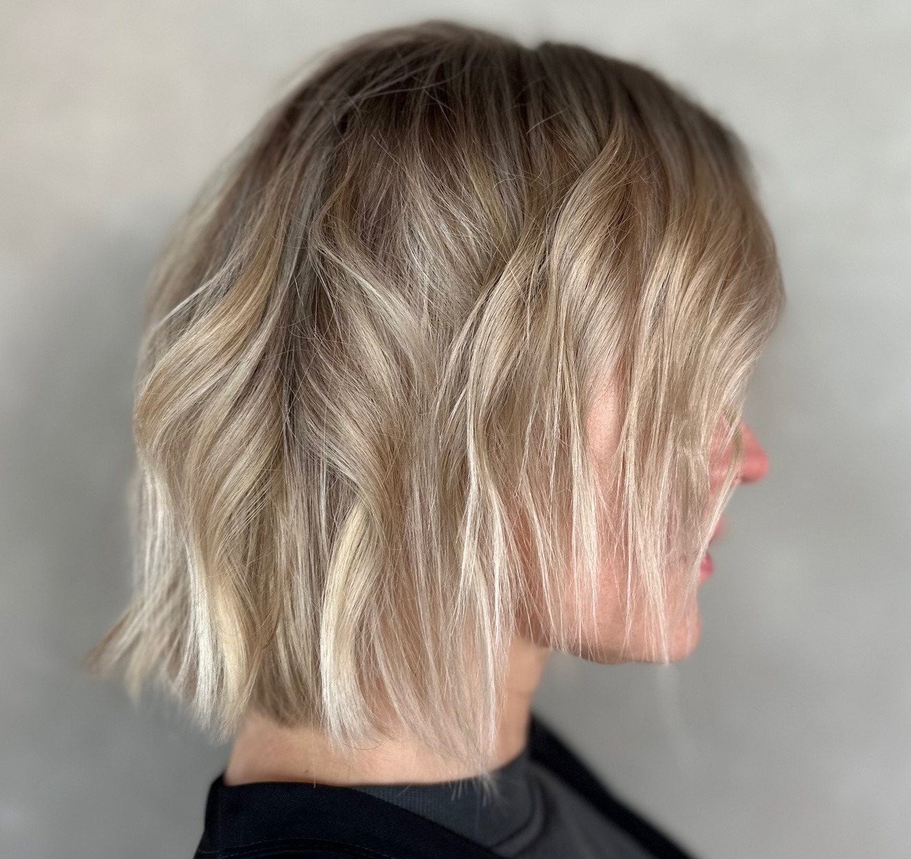 Blonde wavy bob hairstyle, featuring soft waves and a chic bob cut, framing the face elegantly.
