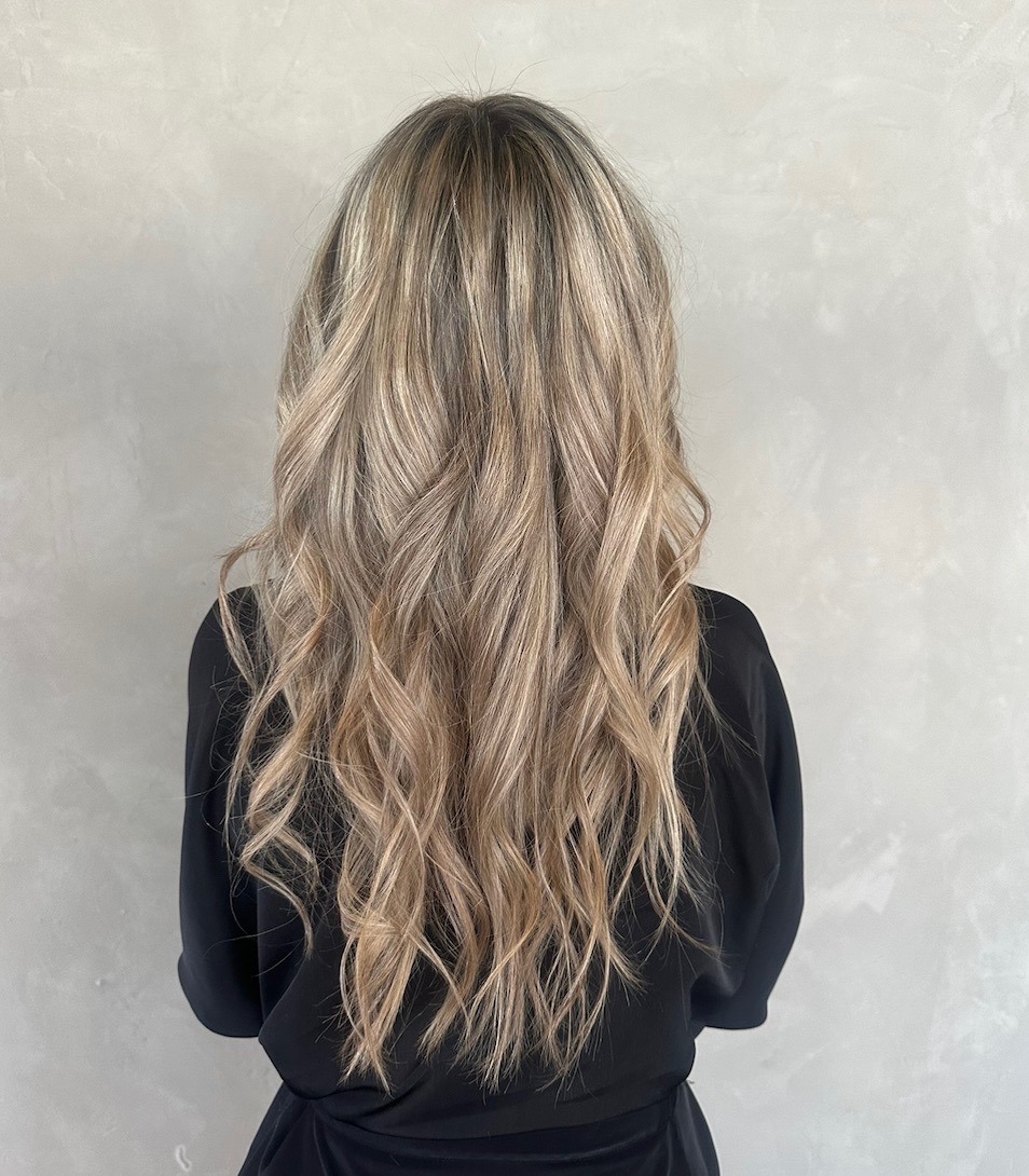 A woman's back view with long, wavy hair cascading down her shoulders.